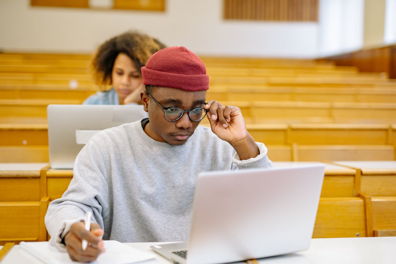 gallery-04 Young adults studying in a university lecture hall with laptops, focused on coursework.
